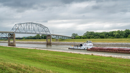 Towboat with barges is passing under a bridge on the Chain of Rocks Canal of MIssissippi River above St Louis