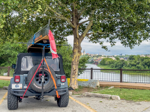 Kansas CIty, KS, USA - July 31, 2023. Jeep Wrangler with a canoe on roof racks in Kaw Point Park - confluence of Kansas and Missouri Rivers.