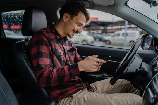 one adult man caucasian with mustaches sit in car use mobile phone