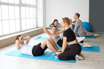 Obraz premium Group of sporty young people training in gym