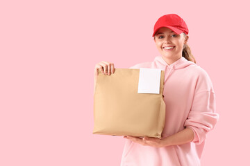 Female courier with paper bag on pink background