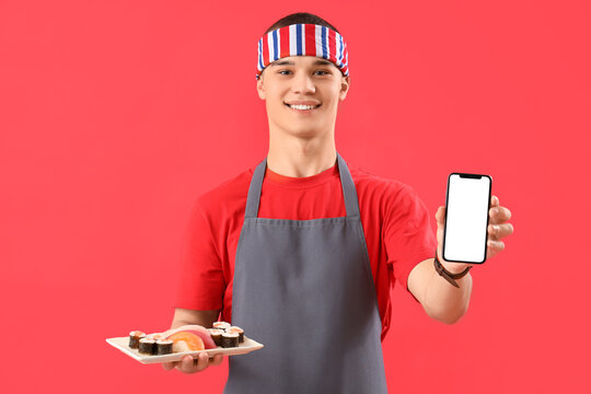 Young man with tasty sushi and mobile phone on red background - Powered by Adobe