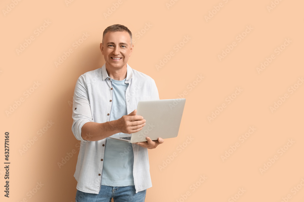 Poster Mature male programmer with laptop on beige background