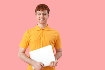 Male programmer with laptop on pink background