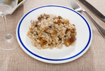 Appetizing pearl barley with slices of fried lard served on dish
