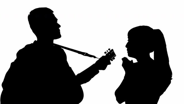 Silhouette of a girl with a guy playing the guitar. black and white mask