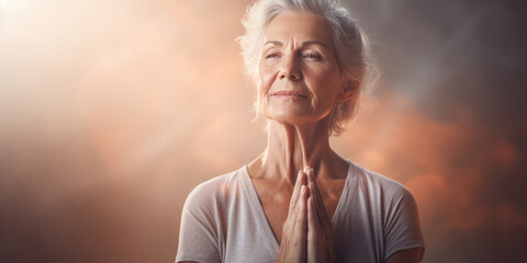 An older, mature and friendly elegant woman meditating and doing yoga with calm and serene demeanor.