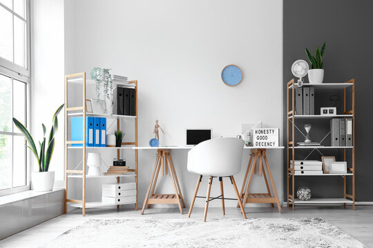 Interior Of Light Office With Modern Workplace And Shelving Units