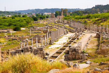 Fototapeta na wymiar Picturesque landscape overlooking the streets with marble columns and antique statues of the ancient city of Perge, currently ..located near Antalya, Turkey