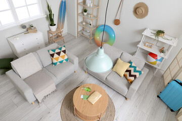 Stylish interior of living room with beach accessories and cocktail on table