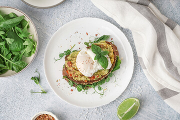 Plate of tasty sandwich with egg on grey background