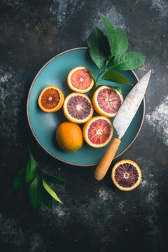 Blood Oranges and knife in Blue Bowl and table