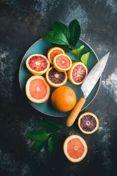Blood Oranges, pink grapefruit and knife in Blue Bowl and table