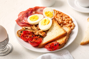 Plate of tasty English breakfast with boiled eggs on white background