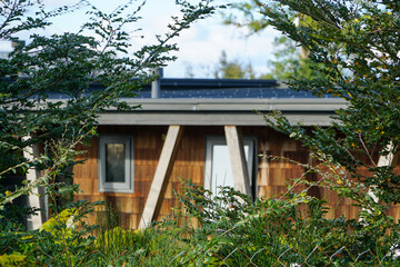 Wooden shingle house nestled among trees.