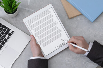 Electronic signature. Man using stylus and tablet at table, top view