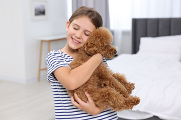 Little child with cute puppy in bedroom. Lovely pet