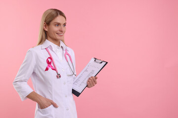 Doctor with pink ribbon, clipboard and stethoscope on color background, space for text. Breast...