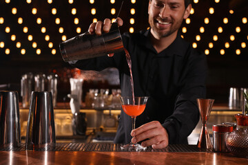 Bartender preparing fresh alcoholic cocktail in bar, selective focus