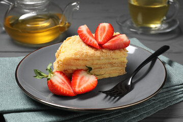 Piece of delicious Napoleon cake with strawberries on table, closeup