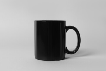 Black ceramic mug on light grey background
