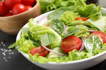 Delicious vegetable salad on grey table, closeup