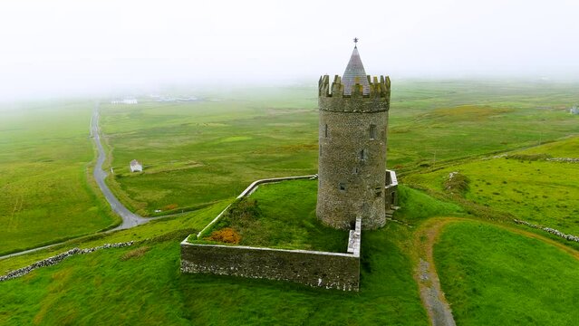Doonagore Castle aerial foggy orbit view, iconic landmark, County Clare, Ireland