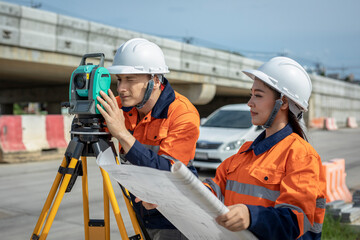 Teamwork of construction surveyors. A construction worker using theodolite surveying optical...