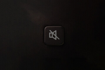 macro close up of remote control mute button on black background