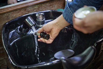 면도솔을 깨끗하게 세척하는 바버샵 직원