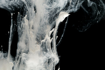 Abstract paint splash isolated on black background. Acrylic ink in water. selective focus.