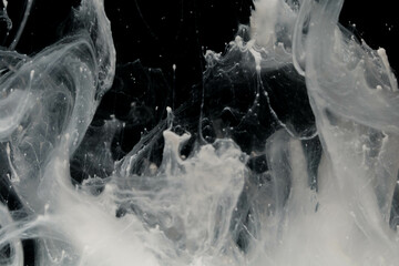 Abstract paint splash isolated on black background. Acrylic ink in water. selective focus.