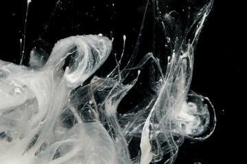 Abstract paint splash isolated on black background. Acrylic ink in water. selective focus.