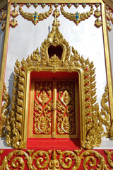 Thai patterned wooden window of a church at a temple in Isaan, Thailand