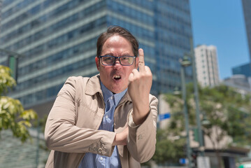 An angry man giving the middle finger saying the f word after being angered and frustrated at...