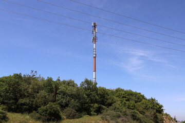 Power electric pole with line wires on insulators.