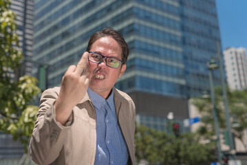 An angry man giving the middle finger saying the f word after being angered and frustrated at...