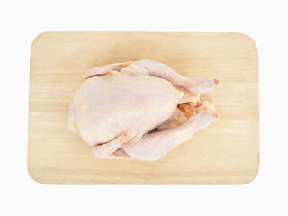 Whole raw chicken on wooden cutting board on white background.