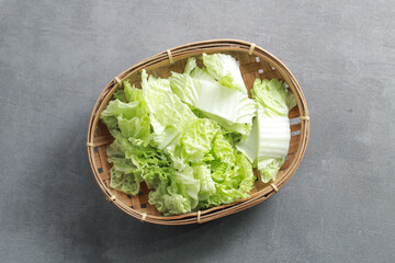 Brassica (Chinese Chives) on a bamboo container with a gray background. Sawi PUtih.