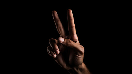 Hand two finger in a victory and peace symbol isolated black background