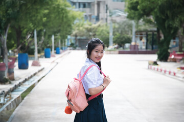 Asian studen back to school for study at Bangkok , Thailand.A cute girl student in a white school uniform is going to school.