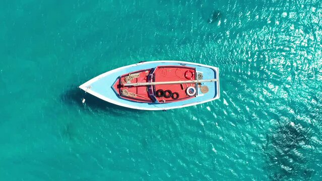 Drone top down perspective of boat mast on deck of ship anchored in sandy caribbean waters