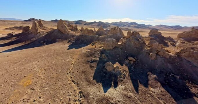FPV drone captures the surreal beauty of Trona Pinnacles bathed in the warm hues of the golden hour. Unique landscape and cinematic appeal.