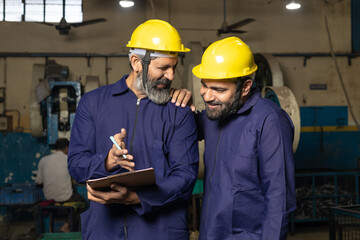 Professional worker or labor discussing some topic and writing detail at factory