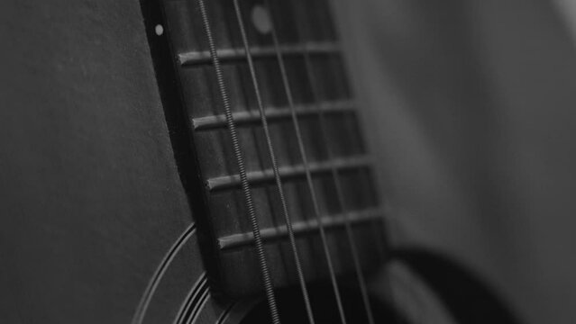 Extreme slow motion of a guitar string plucking in black and white.