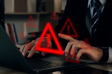 Businessman using computer laptop with warning sign.Notification error and virus detection spyware,...