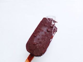 Chocolate ice cream with almonds and taro flavors on a stick on a white background
