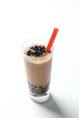 Taiwan popular black boba bubble milk tea with ice in tall glass pearl drink halal food vegan menu in white background with red straw for cafe