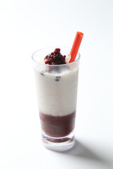 ice cold chilled fresh sweet coconut milk soya drink with red bean paste in glass and red straw beverage halal food vegan menu in white background for cafe