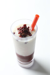 ice cold chilled fresh sweet coconut milk soya drink with red bean paste in glass and red straw beverage halal food vegan menu in white background for cafe